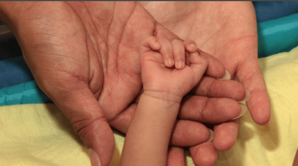 Activistas transexuales Diane Rodriguez y Fernando Machado se convirtieron en padres cogen la mano de su hijo